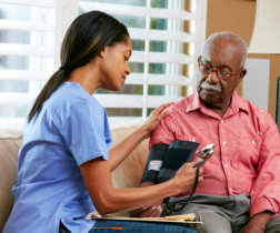 nurse checking senior man's blood pressure